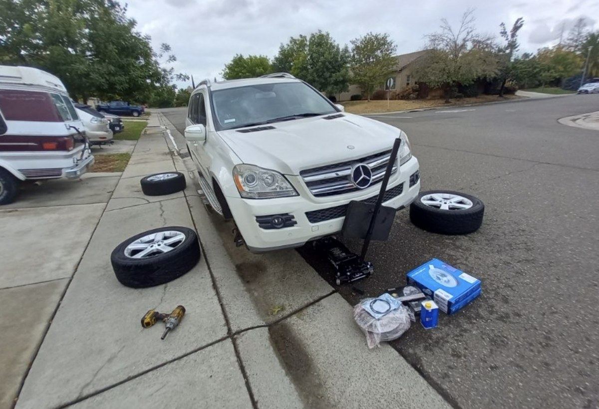 Curbside brake job with parts staged at an Erie home