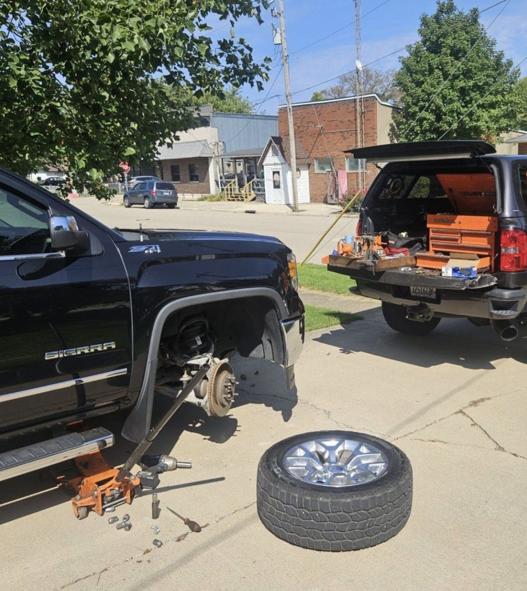 Erie mobile mechanic set up streetside, wheel off and service truck open