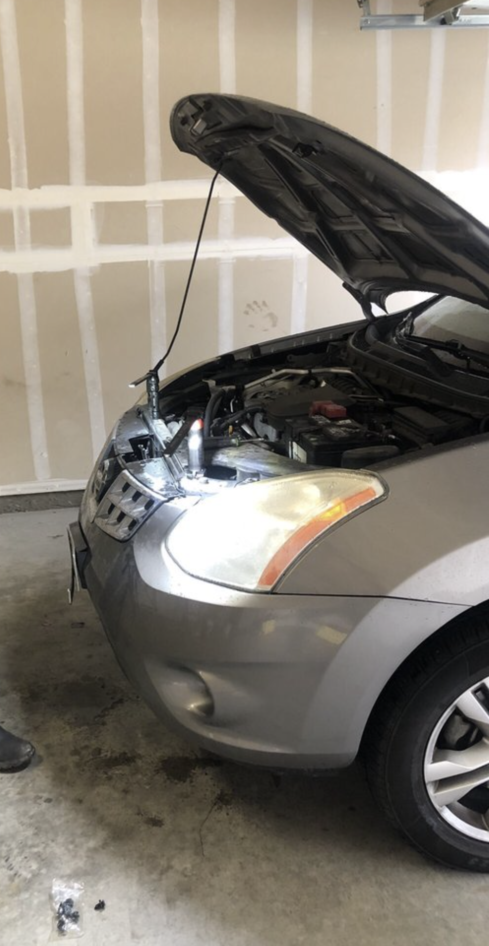 mechanic working on car engine in snowy Erie Pennsylvania driveway